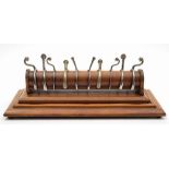 A collection of five sets of Victorian silver plated spurs on a mahogany rack:,