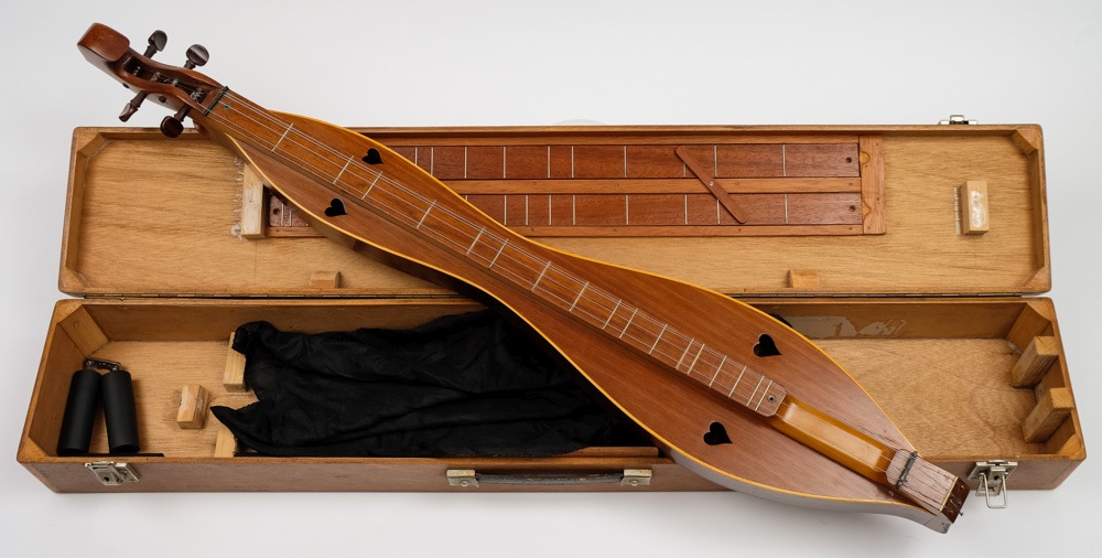 A mahogany dulcimer by F C Bond:, of traditional form with heart shaped sound holes,