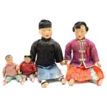 An early 20th century family of four Chinese dolls:, each with painted faces and hands,