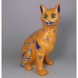 A Mosanic pottery cat: in seated posture with curled tail with inset glass eyes,