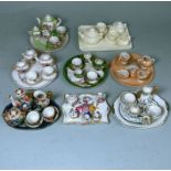 Eight miniature cabaret sets: comprising a bisque porcelain example on a rectangular tray,