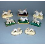 A group of eight Staffordshire porcelain figures of poodles: comprising a matched pair of a bitch