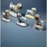 Five Staffordshire porcelain poodle figures: each modelled standing with a basket of flowers in