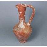 A 1st century Mediterranean terracotta ewer: of footed oviform with slender raised neck,