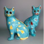 A pair of Mosanic pottery cats: in seated posture with curled tail with inset glass eyes,