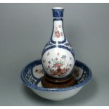 A porcelain bottle vase and matching bowl: enamelled in the famille rose palette with flowers and a