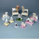 Nine Staffordshire porcelain poodles and a Chamberlain example: comprising a matched pair of