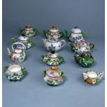 A group of toy florally encrusted porcelain tea ware: comprising nine various tea pots and kettles,