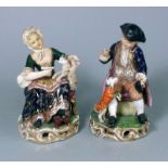 A pair of Derby figures: one of a seated boy with a dog at his feet,