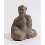 A Chinese pottery seated dignitary: with left arm raised and head turned,