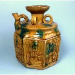 An Oriental brown and green glazed pottery vessel: with wide neck and scroll spout,