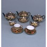 A Derby porcelain miniature tea service in the Witches pattern: comprising three circular tea pots