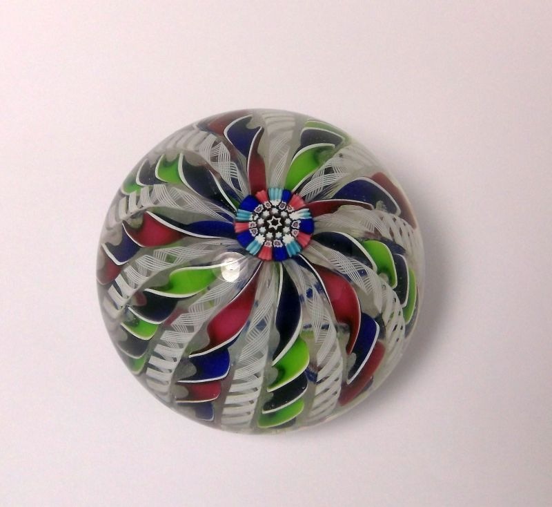 A John Deacons glass paperweight: set with a central cluster of canes with radiating colourful