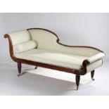 Regency mahogany chaise lounge, the arched frame with carved foliate heads, pad back and rest and