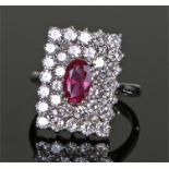 Striking 14 carat white gold ruby and diamond set ring, the central approximately 0.70 carat oval