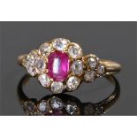 Yellow metal diamond and ruby ring, the central ruby surrounded with fourteen diamonds, ring size