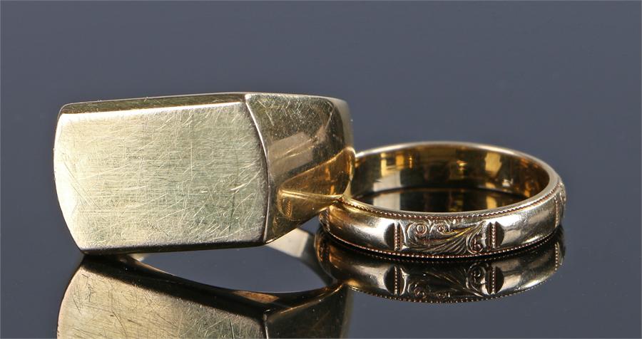 Two 18 carat gold rings, the first with a flat head, rign size V, together with a band with scroll