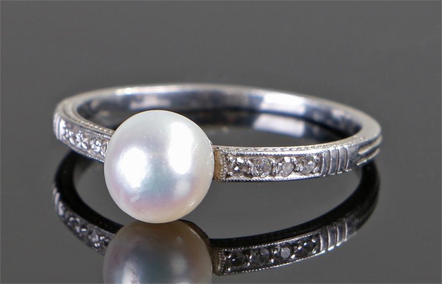 White metal natural pearl and diamond set ring, the pearl at approximately 1.92 carats flanked by