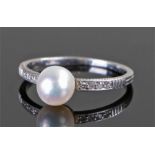 White metal natural pearl and diamond set ring, the pearl at approximately 1.92 carats flanked by