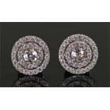 Striking pair of diamond set earrings, the central diamond surround by two bands of diamonds, each