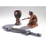 New Zealand carved figure of a crouching Maori, a Trobriand Islands lizard and a cup, (3)