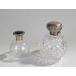 Two silver and glass bottles, the first with a tortoiseshell lid, 9.5cm high, the second embossed