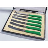 Cased set of knives, with green bakelite handles, silver collars, stainless steel blades, cased