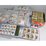 ** Large quantity of cigarette cards and stamps. Loose stamps arranged by country in tins. Cigarette
