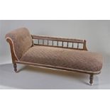 Edwardian chaise longue, the stuff over upholstered seat back and pad bar above spindle supports,