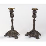 Pair of 19th Century bronze candlesticks, the traced of gilding to the leaf scone, above a tulip