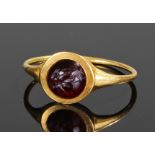 Roman gold and garnet ring, the carved garnet with a winged figure, circular mount with slender