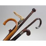 Five walking sticks to include a horse measuring stick, a horn and silver collared stick, a bamboo