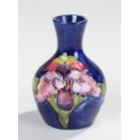 Moorcroft vase, flowers on a blue ground, paper label attached, 10cm high