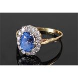 Yellow metal diamond and sapphire set ring. The central sapphire surrounded by diamonds, ring size