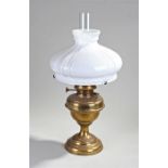 Milk glass oil lamp, the wide milk glass shade above a brass vase body, 45cm high