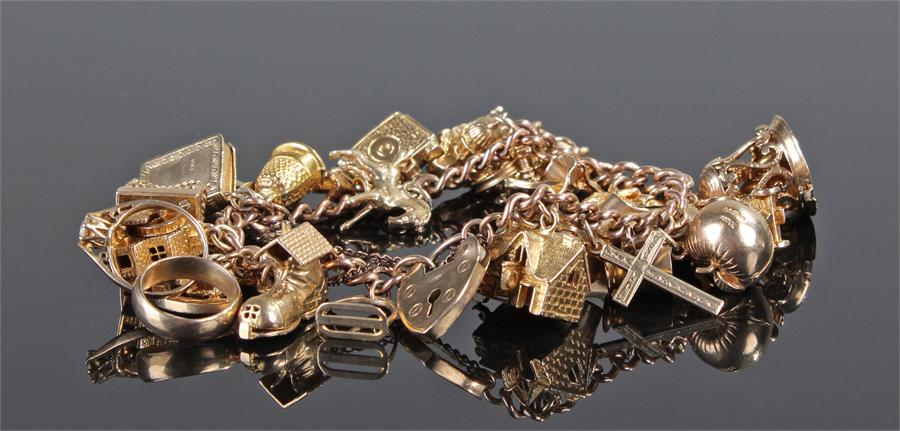 9 carat gold charm bracelet. The chain link with a collection of charms to include houses, rings,