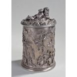 Silver plated tobacco jar with a reclining man to the lid above raised decorated drinking festival
