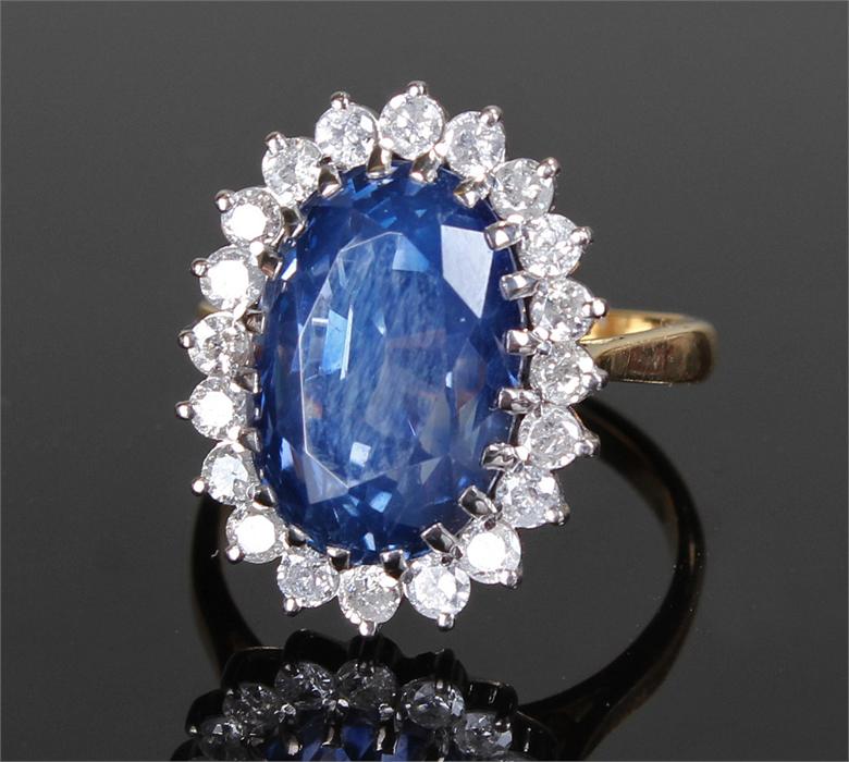 18 carat gold, sapphire and diamond ring. The central, unheated, oval brilliant step cut sapphire at