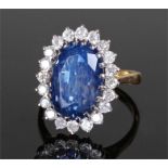 18 carat gold, sapphire and diamond ring. The central, unheated, oval brilliant step cut sapphire at