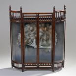 Edwardian fan display case, the finial top above bow glass sides and central door, raised on a stile