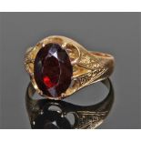 18 carat gold and garnet ring, the central garnet with engraved shoulders, ring size Q