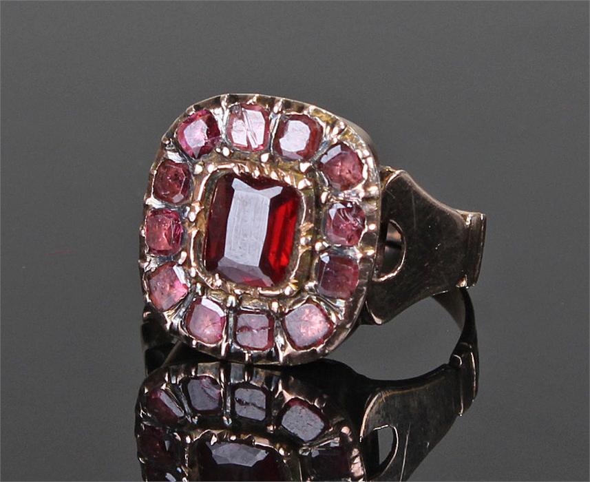 Early 19th Century yellow metal and garnet set ring, the central garnet surrounded by further