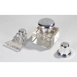 Three inkwells to include a silver and coin set example, a novelty bell example and another (3)