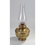 The Miller Lamp oil lamp, made in the USA, the glass chimney above a wide foliate and C scroll base,