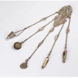 Silver chatelaine, with fret pierced leaf clip top above drop chains and various tools attached (