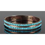 Yellow metal and turquoise set bangle with two rows of turquoise stones to the bangle, 5.6cm wide