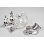 Mixed silver to include two peppers, two napkin rings, a glass and silver collared bottle and a