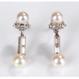 Pair of white metal, pearl and diamond mounted earrings, with a pearl above three round diamonds and