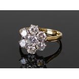 18 carat gold diamond set ring, set with seven diamonds in the form of a flower head, the central