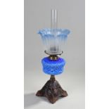 Blue glass and iron based oil lamp, the clear glass chimney with frosted blue glass shade above a